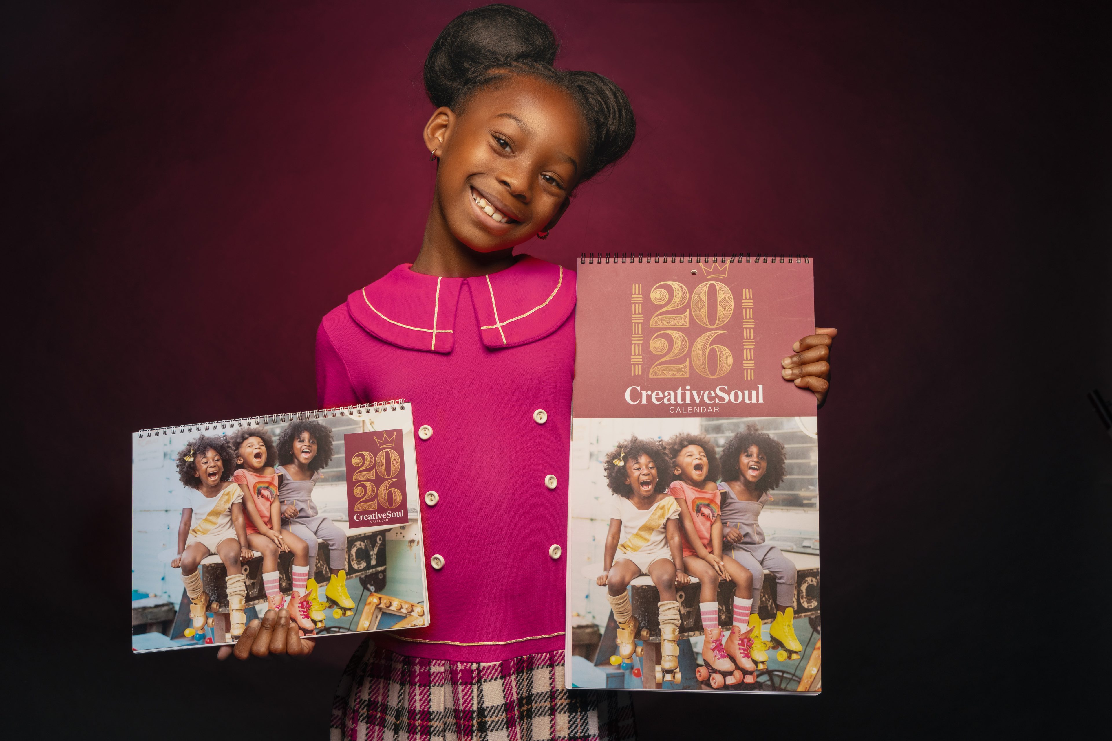Girl holding the 2026 CreativeSoul wall calendar in both sizes