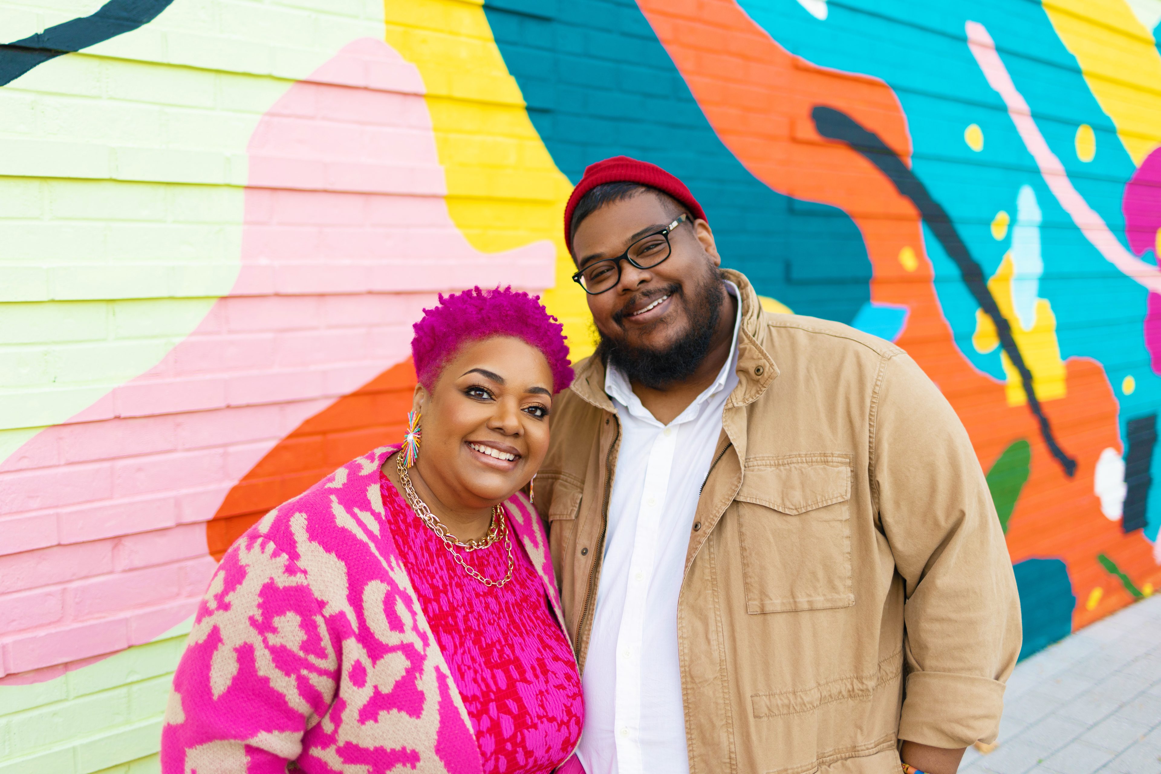 Regis and Kahran Bethencourt in front of a colourful mural