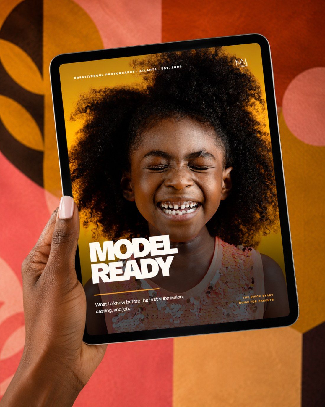 Hand holding a tablet showing the Model Ready guide against a bold pattern