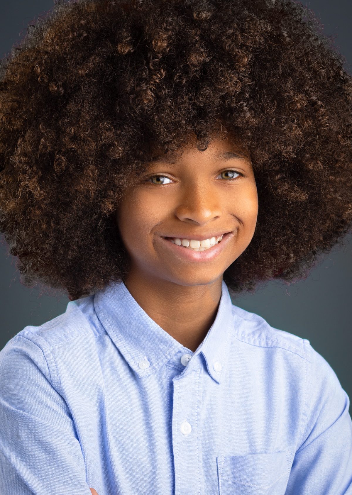 Boy with an afro in a light blue shirt