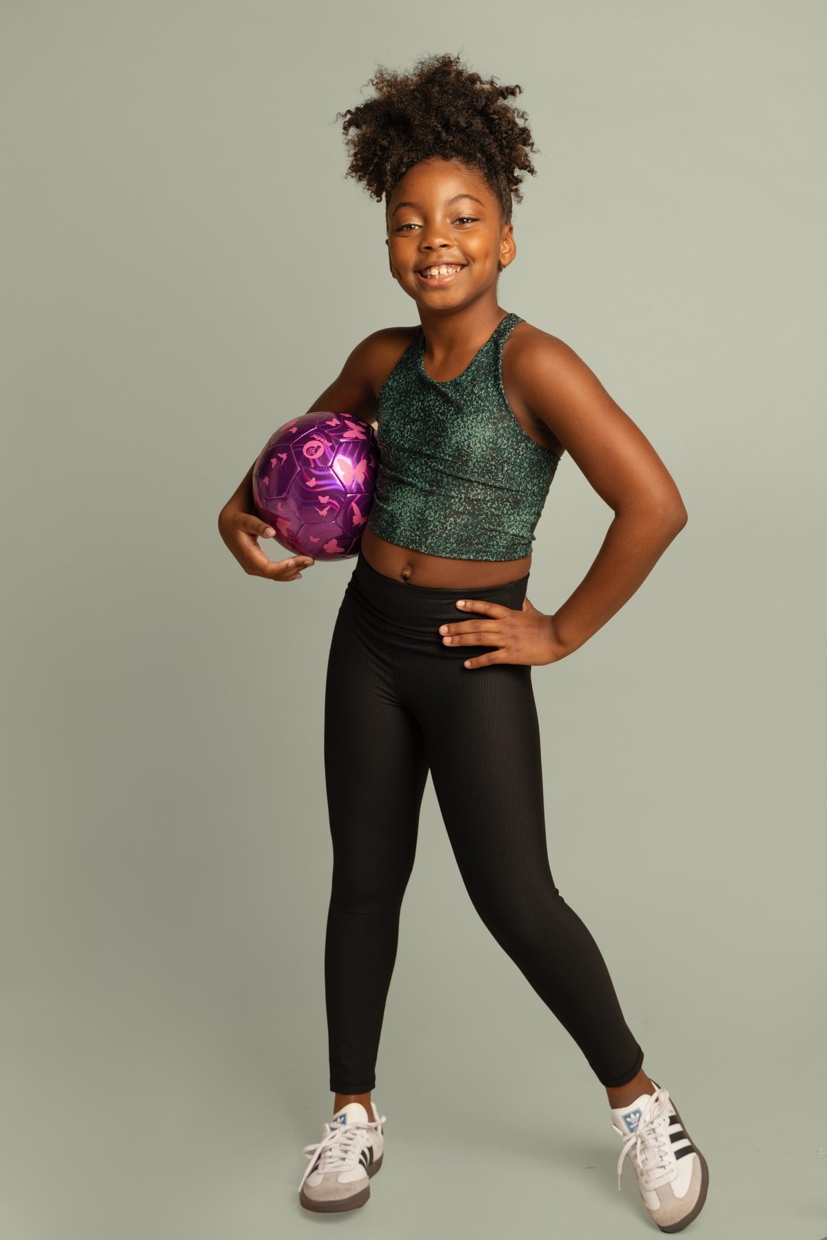 Girl in athletic wear holding a football