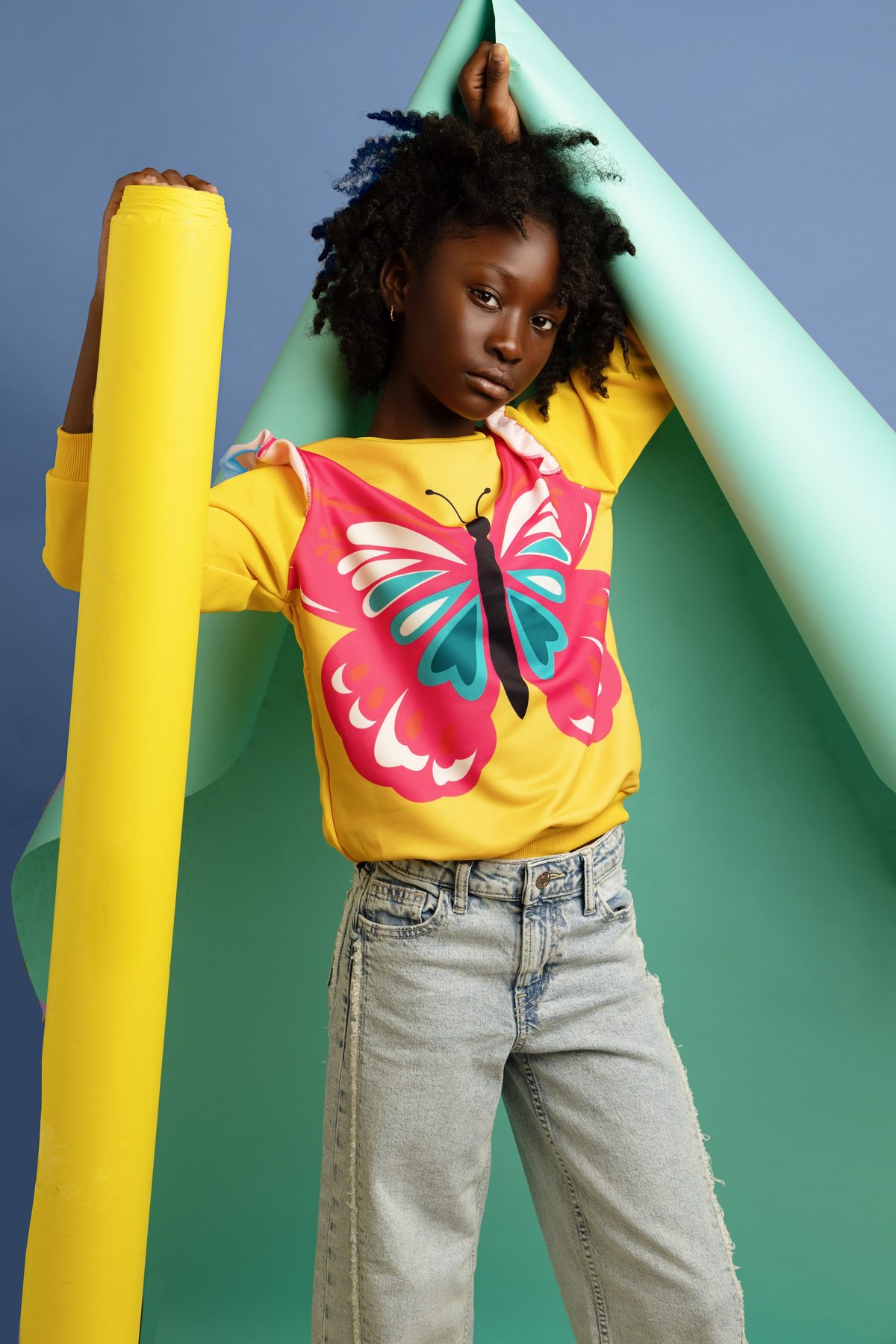 Girl in a butterfly tee against a paper backdrop