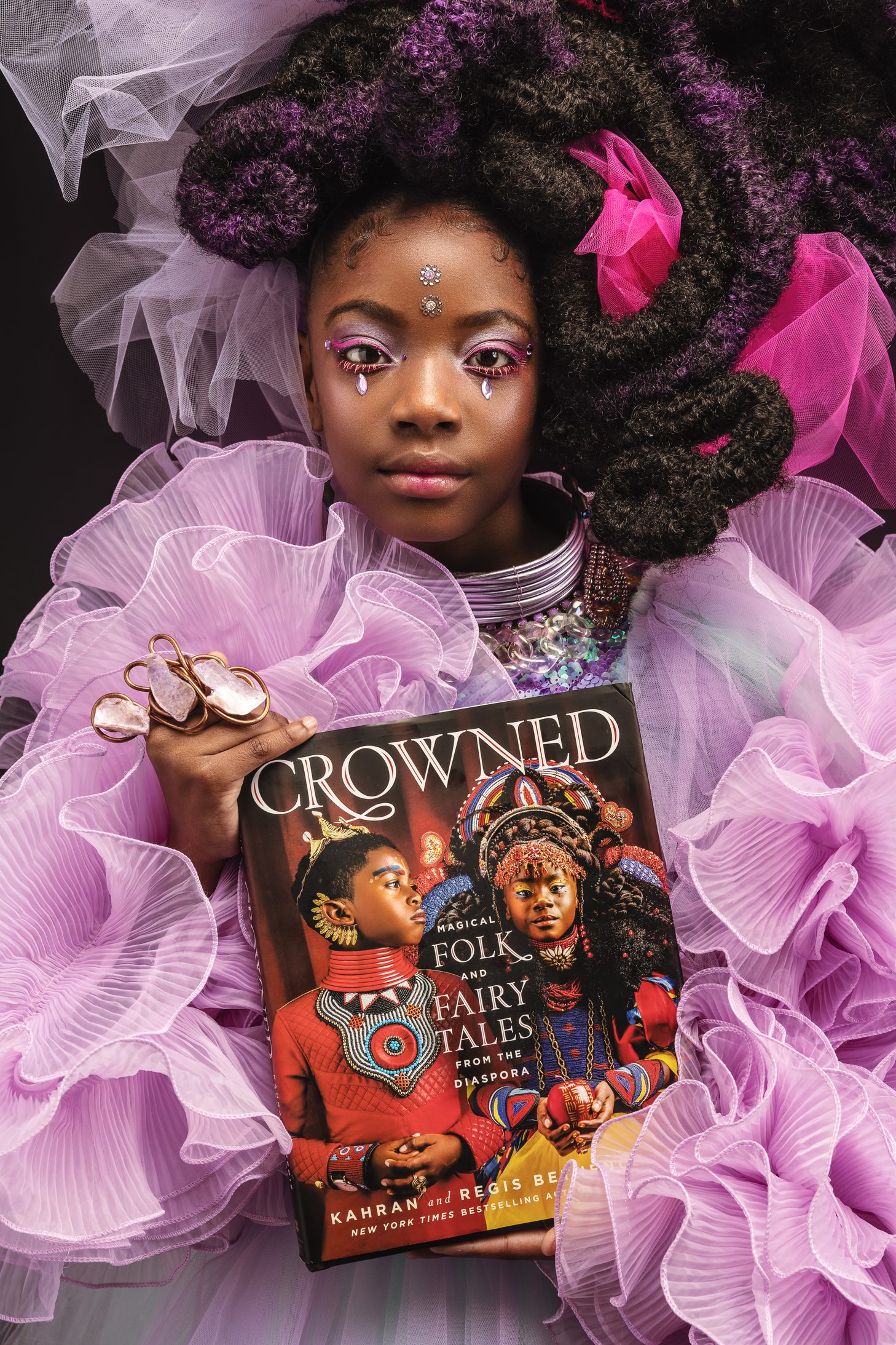 Girl in lavender tulle holding the Crowned book