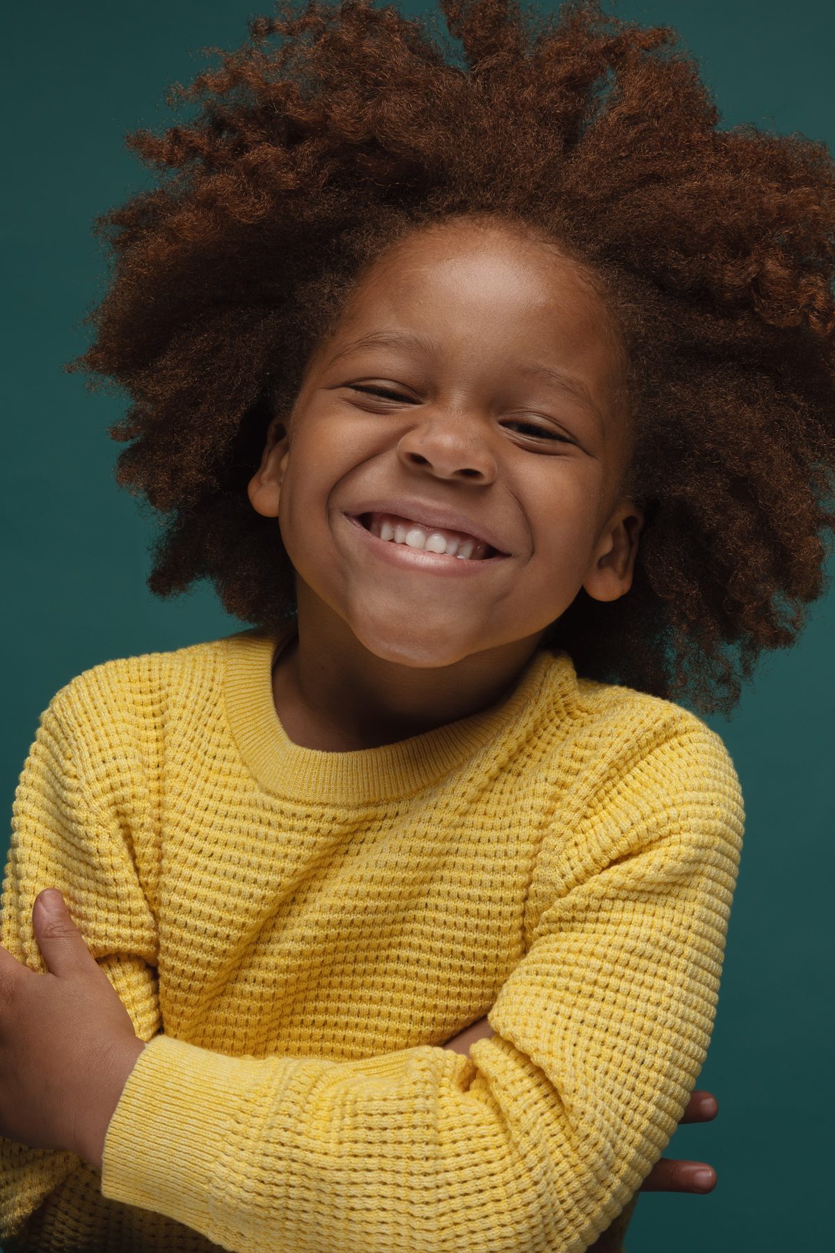 Girl in a yellow sweater with her arms crossed