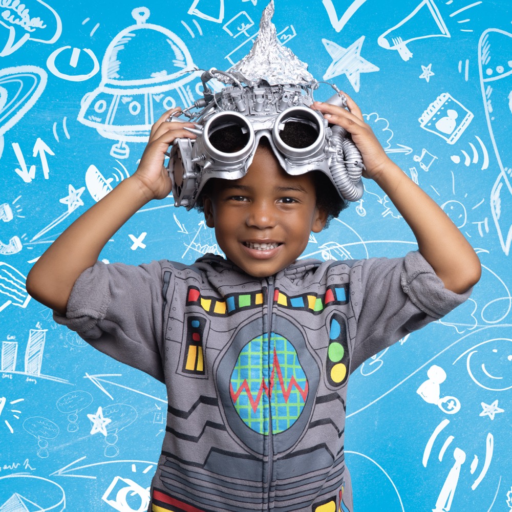 Child inventor in homemade goggles against a doodled blue backdrop