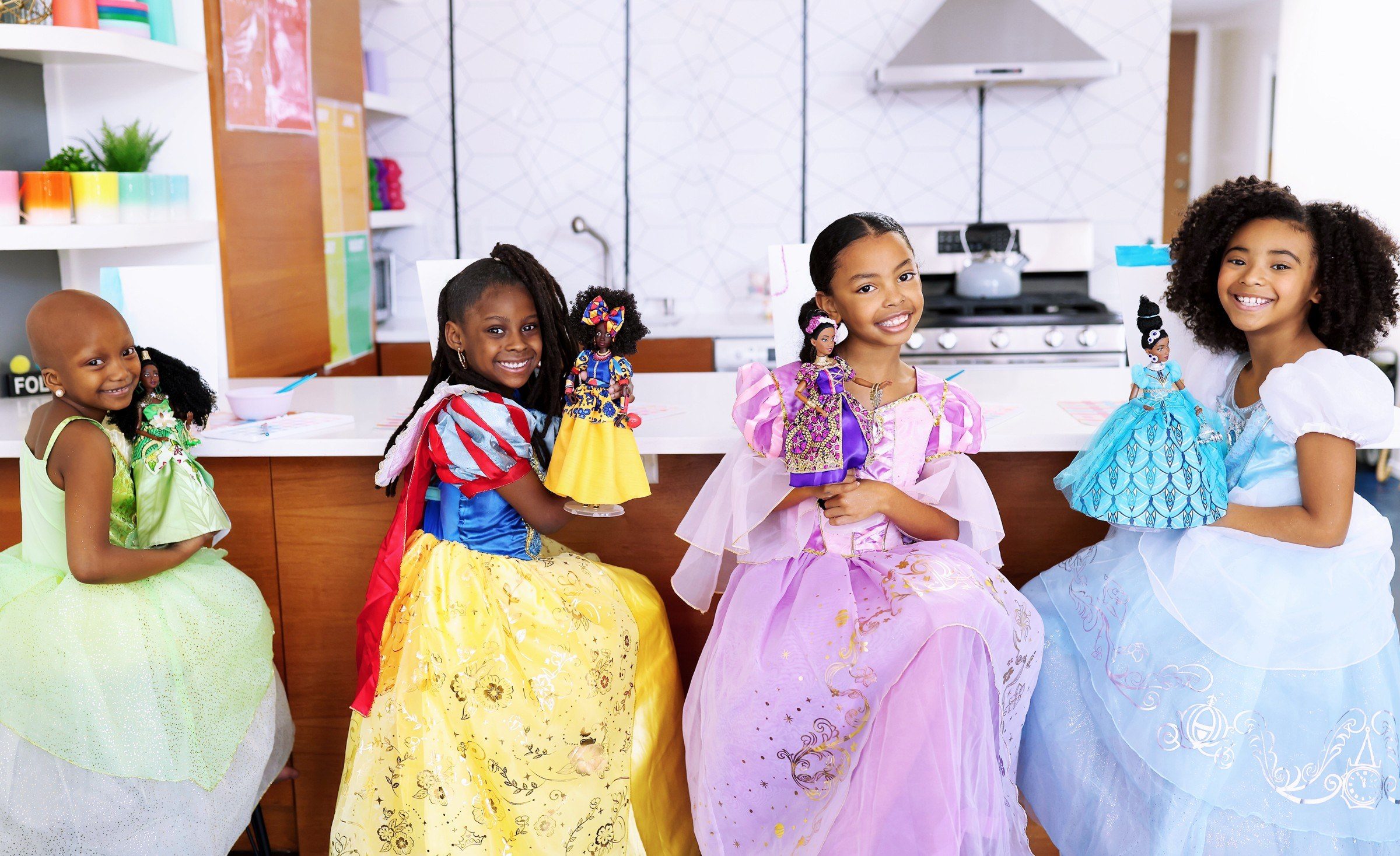 Four girls in princess gowns holding the CreativeSoul Disney Princess dolls